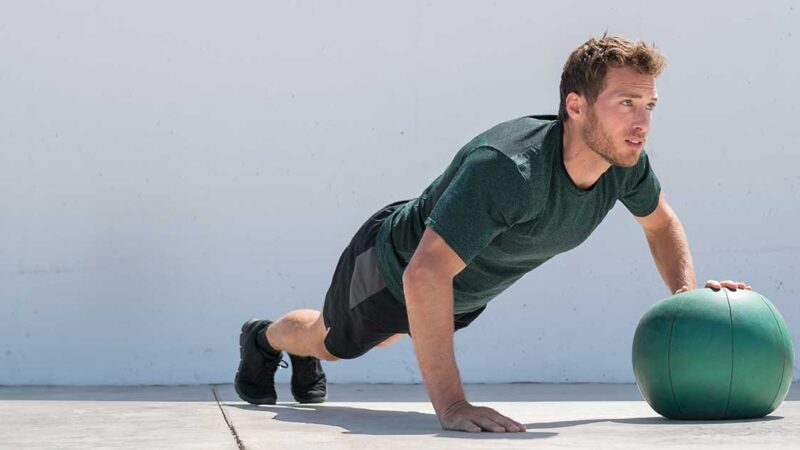 atleta che sta steso a terra reggendosi con un braccio mentre con l'altro regge una palla