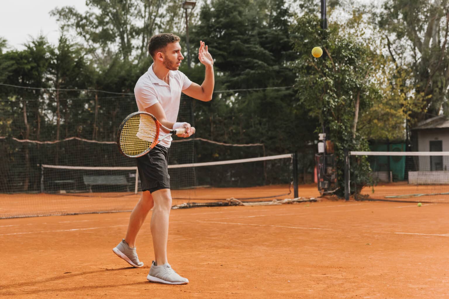 tennista uomo che lancia la palla