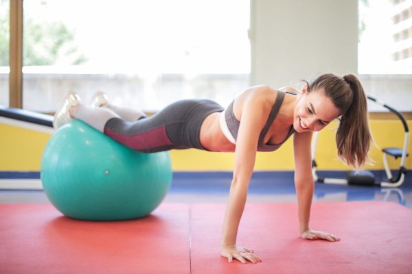 ragazza che pratica medical fitness sul tappetino e con la palla nel centro fisioterapico Fisioklinic Tribiano